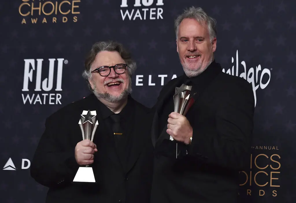 Guillermo del Toro, izquierda, y Mark Gustafson posan en la sala de prensa con el premio a mejor largometraje animado por Guillermo del Toros Pinocchio. (Foto Jordan Strauss/Invision/AP)