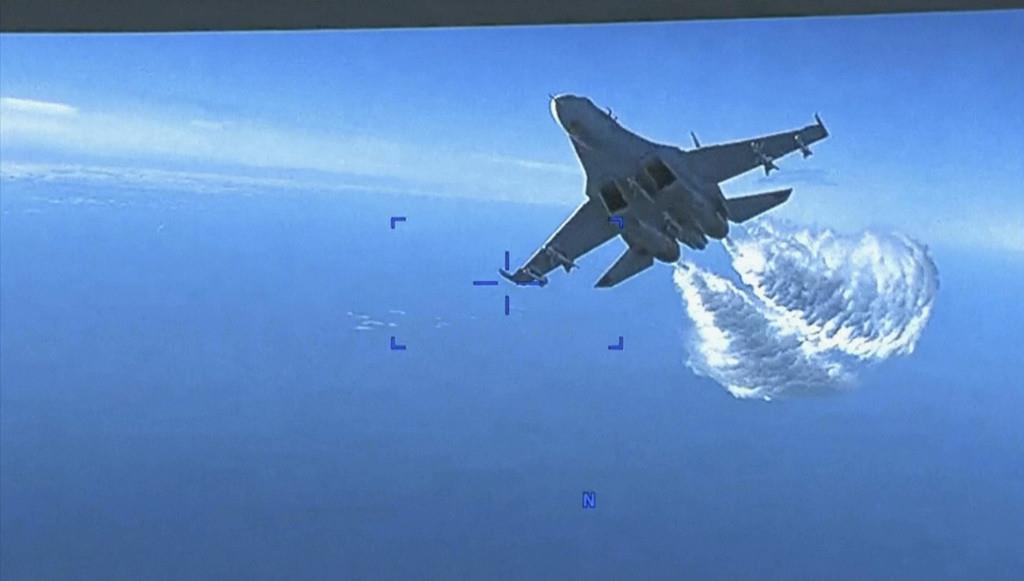 En la imagen, tomada de un video distribuido el 16 de marzo de 2023, un avión Su-27 ruso se acerca a la parte trasera de un dron estadounidense MQ-9 y comienza a arrojar fuel a su paso, sobre el Mar Negro, dijo el Pentágono. (Departamento de Defensa de EEU