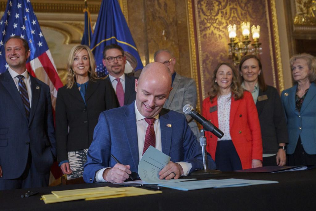 El gobernador Spencer Cox promulga dos proyectos de ley que regulan el uso de las redes sociales durante una ceremonia en el Capitolio estatal, en Salt Lake City, el jueves 23 de marzo de 2023. (Trent Nelson/The Salt Lake Tribune vía AP)