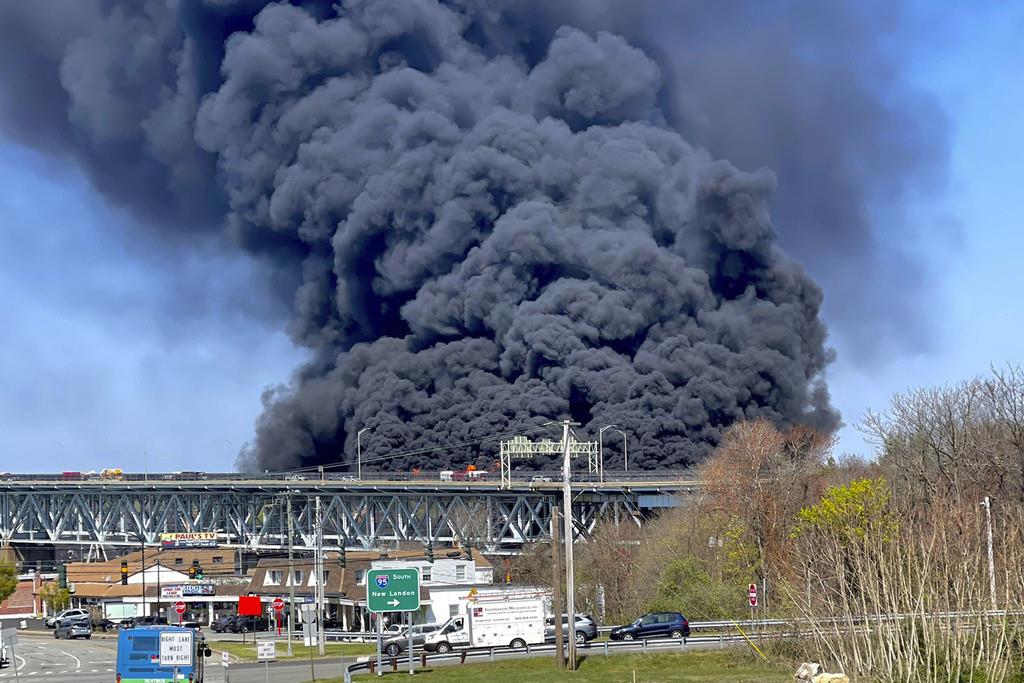 En esta foto provista por la policía estatal de Connecticut, gruesas columnas de humo se alzan de un incendio provocado por el choque entre un camión cisterna de combustibles y un auto en el puente Gold Star Memorial en Groton, Connecticut, viernes 21 de a