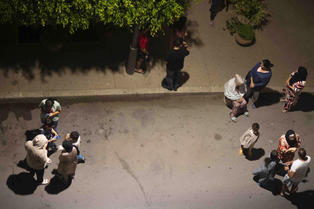 Personas revisan noticias en sus teléfonos después de un sismo en Rabat, Marruecos, el viernes 8 de septiembre de 2023. (AP Foto/Mosaab Elshamy)