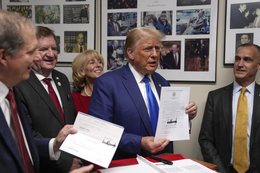 El precandidato presidencial republicano, el expresidente Donald Trump, firma su registro para aparecer en la primaria presidencial republicana rumbo a 2024, el lunes 23 de octubre de 2023, en el congreso estatal de Nueva Hampshire, en Concord. (AP Foto/Ch