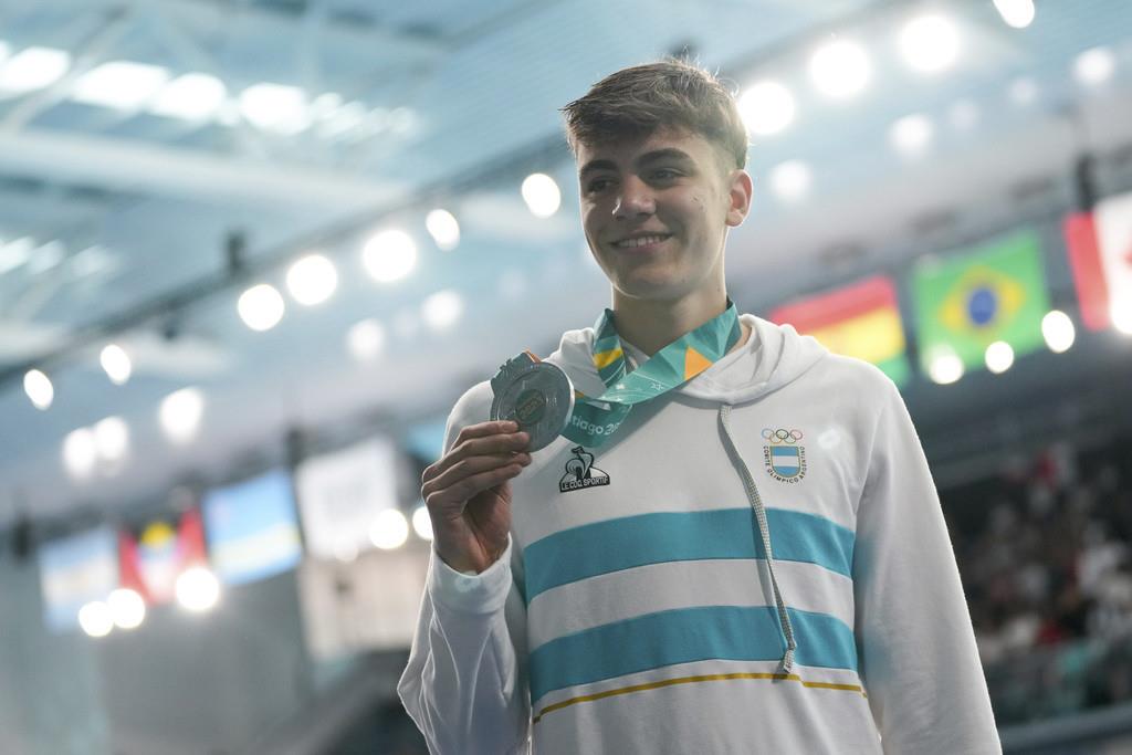 El argentino Ulises Saravia posa con la medalla de plata de los 100 metros estilo pecho de la natación de los Juegos Panamericanos en Santiago, Chile, el lunes 23 de octubre de 2023. (AP Foto/Silvia Izquierdo)