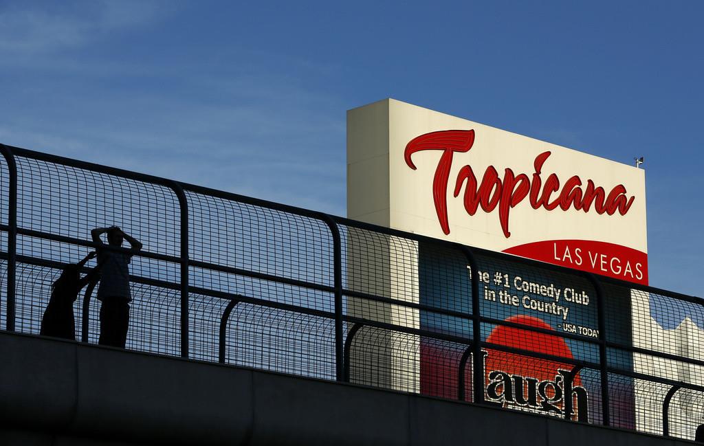 En esta fotografía del 4 de agosto de 2015, unas personas se detienen en un puente peatonal junto al hotel y casino Tropicana, en Las Vegas. (AP Foto/John Locher, Archivo)