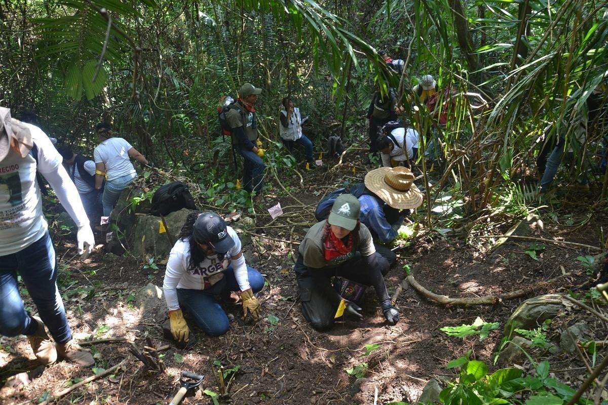 Personas de colectivos en búsqueda de personas desaparecidas en una de las fosas. Foto: Yahoo Noticias.