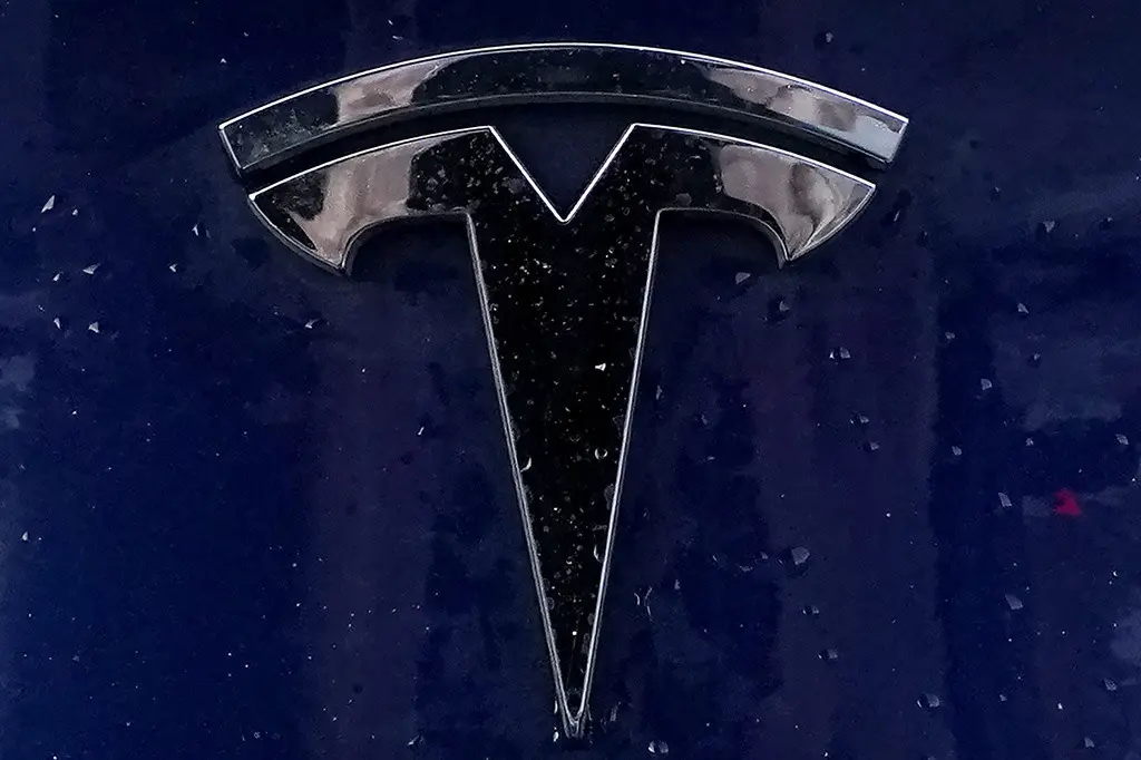 El emblema de un vehículo eléctrico Tesla yace sobre uno de ellos el domingo 21 de febrero de 2021, en Boston. (Foto AP/Steven Senne)