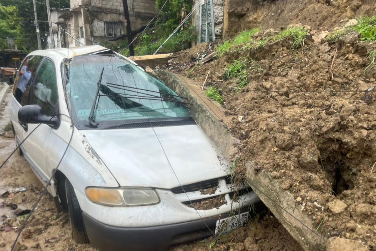 Una camioneta resultó aplastada por una barda tras el deslave. Foto: Axel Hassel