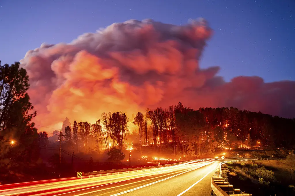 En la imagen, tomada con un tiempo de exposición prolongado, el incendio Park arde a lo largo de la Carretera 32, en la comunidad de Forest Ranch del condado de Butte, California, el jueves 25 de julio de 2024. (AP Foto/Noah Berger)