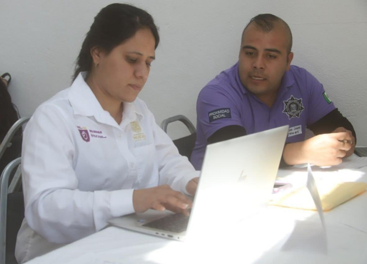 Personal de la Secretaría de las Mujeres de Nuevo León y un policía municipal revisando los temas en las mesas Somos tu red de apoyo. Foto: Facebook Gobierno de García.