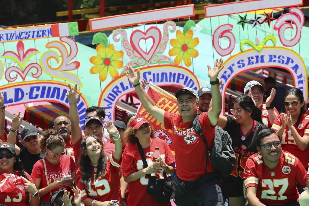 Seguidores de los Chiefs de Kansas City celebran en trajineras que los transportan por los canales de Xochimilco, en Ciudad de México, el domingo 1 de septiembre de 2024 (AP Foto/Ginnette Riquelme)