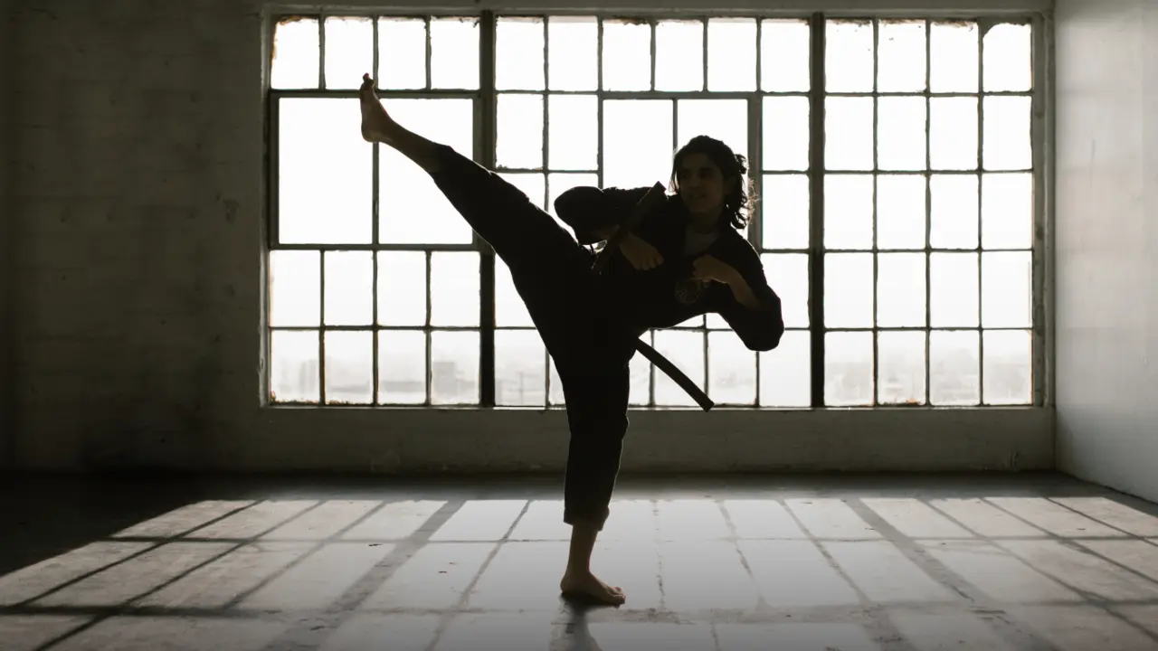 Mujer practicando Taekwondo en dojo / Imagen ilustrativa de Canva