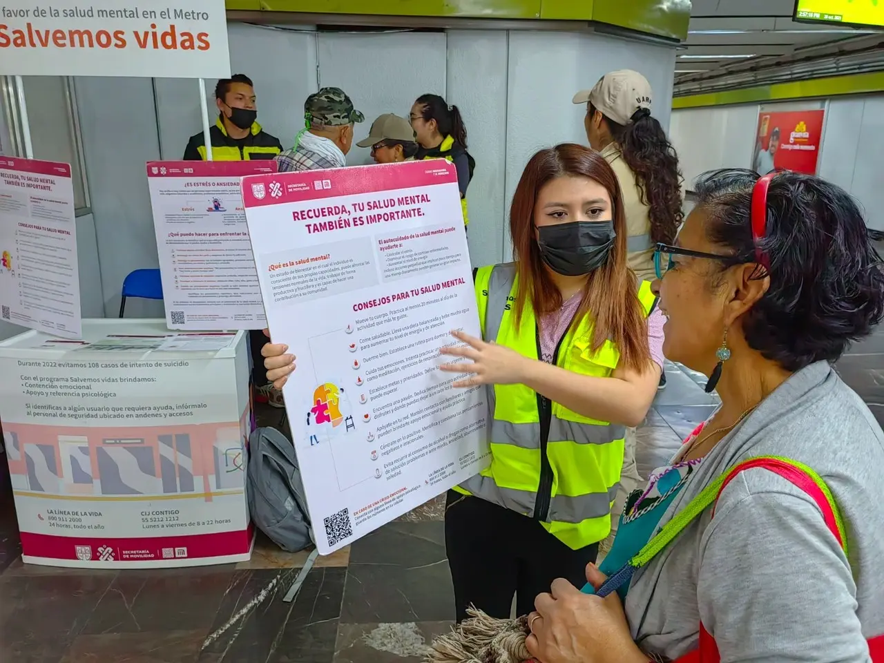 Personal del Metro con capitalina hablando del programa Salvemos Vidas. Foto: @MetroCDMX